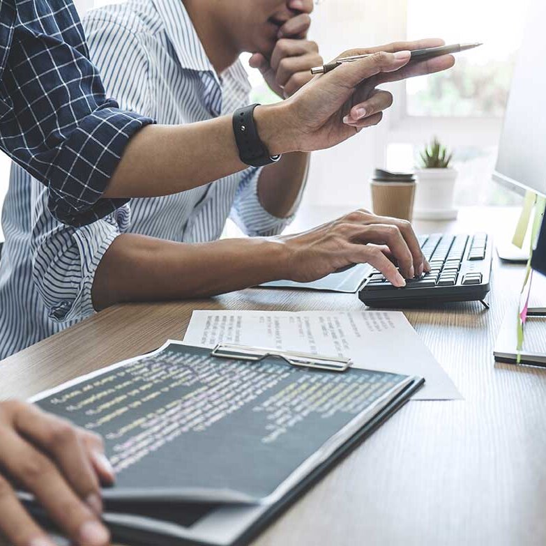 Zwei Personen die sich vorm iMac besprechen